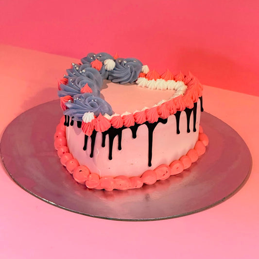 side view of a pink heart-shaped cake made with Ben & Jerry's ice cream in Adelaide, showcasing its rich chocolate drip decoration.