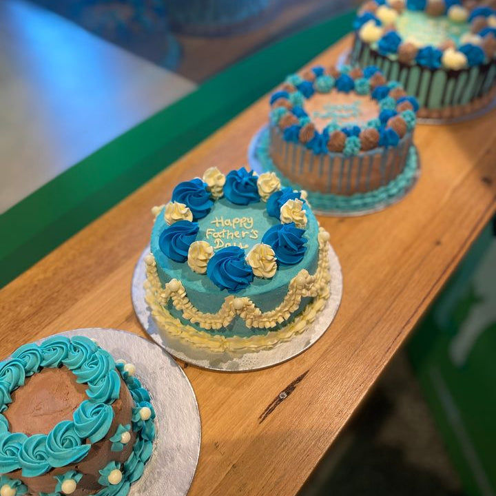 Close-up of the Father's Day-inspired blue and white decorations on a celebration cake handcrafted in Adelaide using Ben & Jerry's ice cream