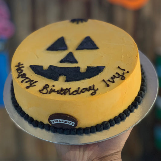 Front view of a pumpkin-themed Halloween birthday cake made with Ben & Jerry's ice cream in Adelaide, showcasing its frightening facial design.