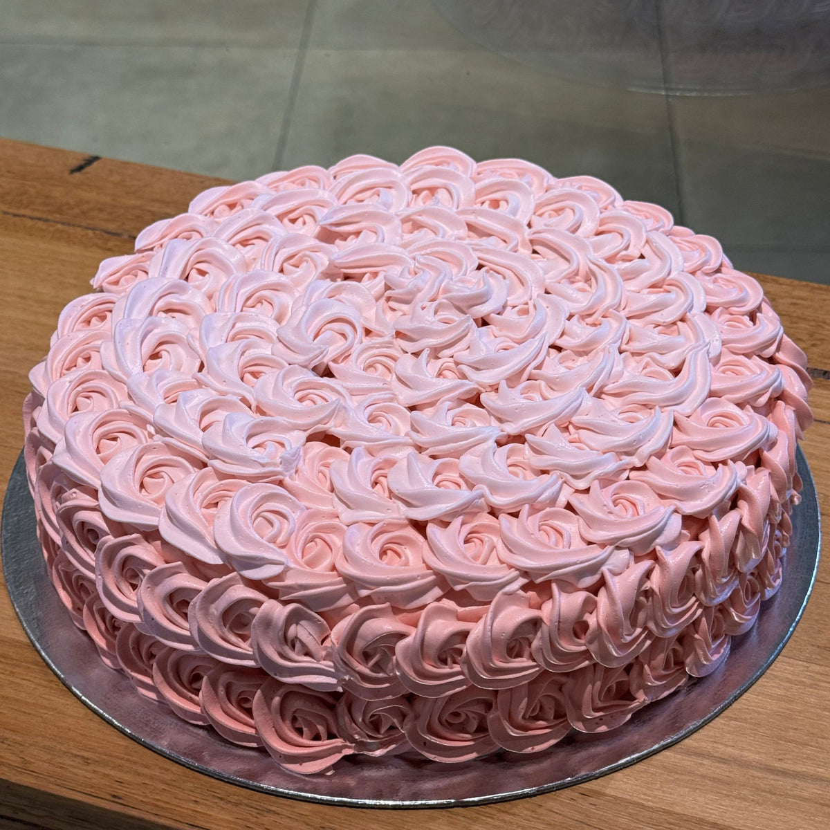 Full view of an elegant rosette birthday cake handcrafted in Adelaide using Ben & Jerry's ice cream, featuring beautiful floral-inspired decorative piping.