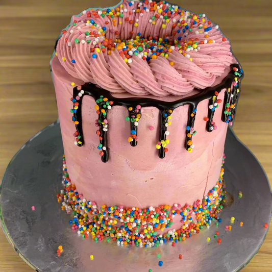 Front view of a classic pink tall cake made with Ben & Jerry's ice cream in Adelaide, showcasing its chocolate drip and colourful sprinkle decorations.