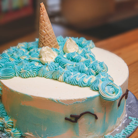 close up of a handcrafted unicorn ice cream cake showcasing its classic round shape and whimsical unicorn-themed design.