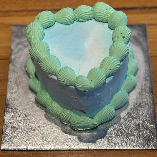 top view of a vintage heart cake made with Ben & Jerry's ice cream in Adelaide, showcasing its bold green and blue piped borders.