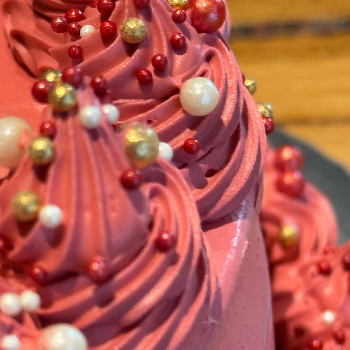 Close-up of delicate pearl accents and decorative piping on a maroon vintage cake made in Adelaide using Ben & Jerry's ice cream.