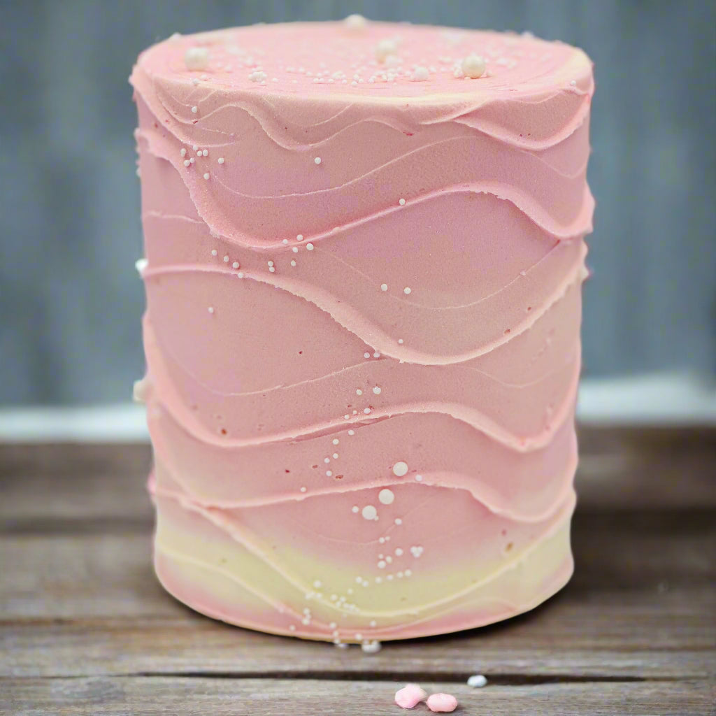 Front view of a baby pink and white birthday cake in Adelaide, showcasing its elegant wave-effect finish and minimalist styling.