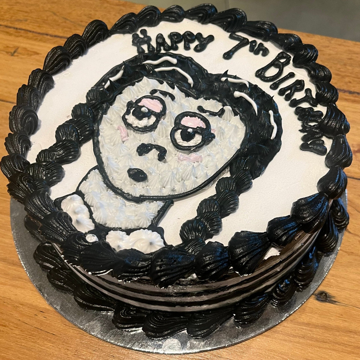 Side view of a handcrafted Wednesday Addams ice cream cake in Adelaide made using Ben & Jerry's ice cream, highlighting its gothic-inspired details.