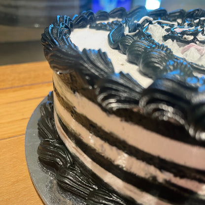 Close-up of Wednesday Addams-inspired decorations on a themed birthday cake handcrafted in Adelaide using Ben & Jerry's ice cream.