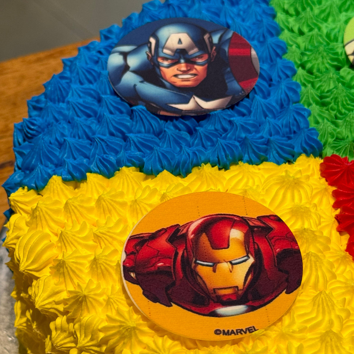 close up of an Avengers-themed ice cream cake showcasing colourful Marvel superhero decorations for a kids' birthday party.