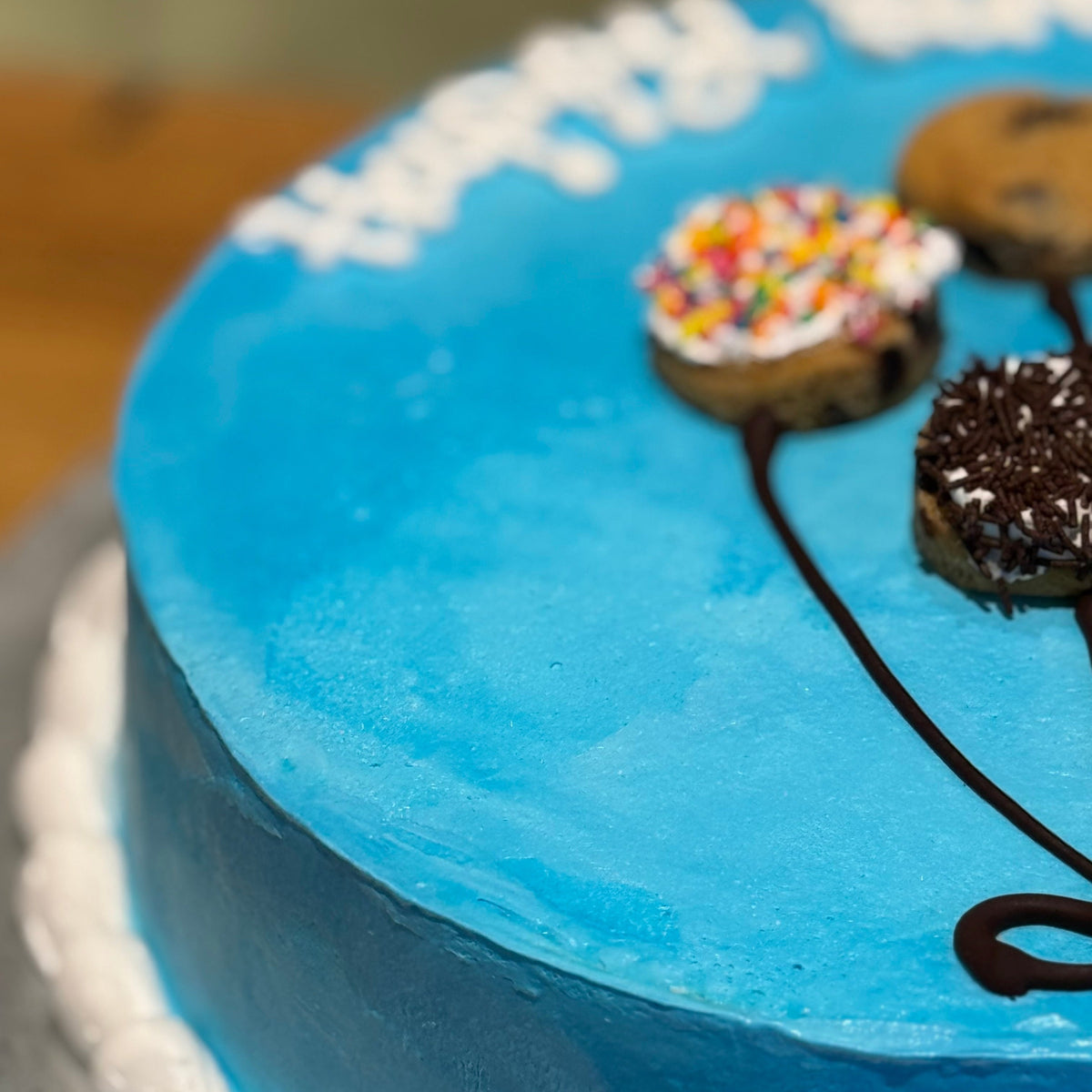 Close-up view of cheerful balloon-inspired decorations on a handcrafted birthday ice cream cake.