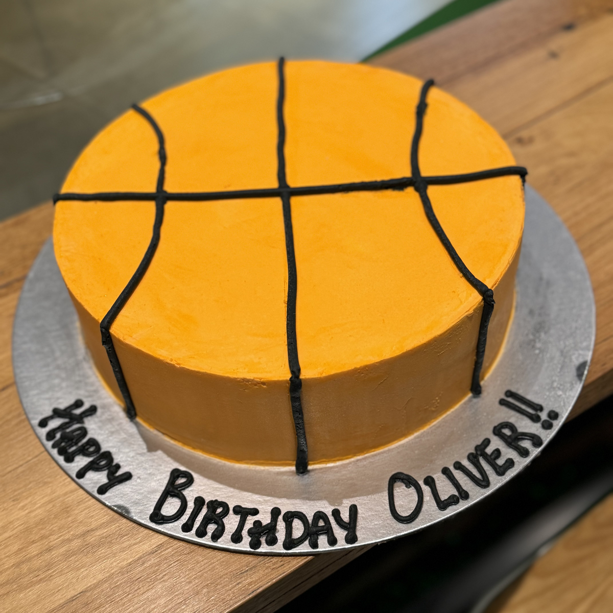 top view of a basketball-themed birthday ice cream cake featuring a simple round shape and recognisable basketball pattern.