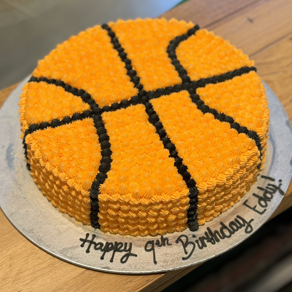 top view of a handcrafted round basketball cake made with Ben & Jerry's ice cream in Adelaide, highlighting its traditional round shape and sporty finish.