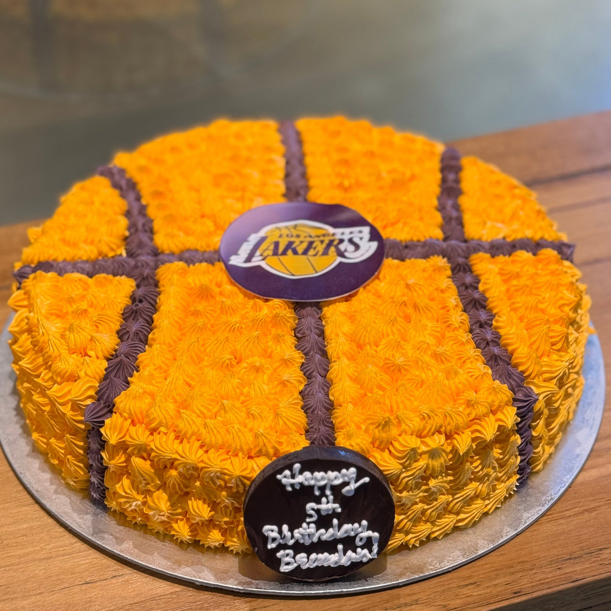 top of the orange and black basketball-inspired decorations on a round birthday cake handcrafted in Adelaide using Ben & Jerry's ice cream.