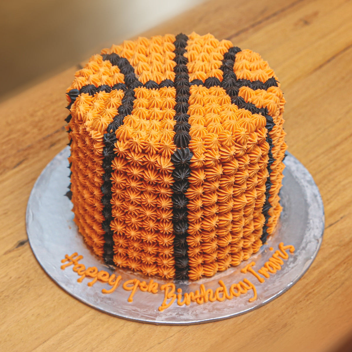 Full view of a tall basketball birthday ice cream cake with sporty basketball-inspired decorations and an eye-catching vertical design.