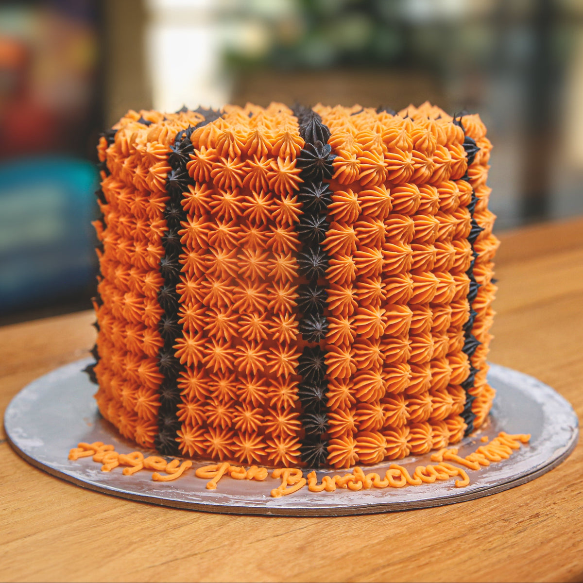 front view of a tall basketball birthday cake highlighting its impressive height and sports-inspired decorative finish.
