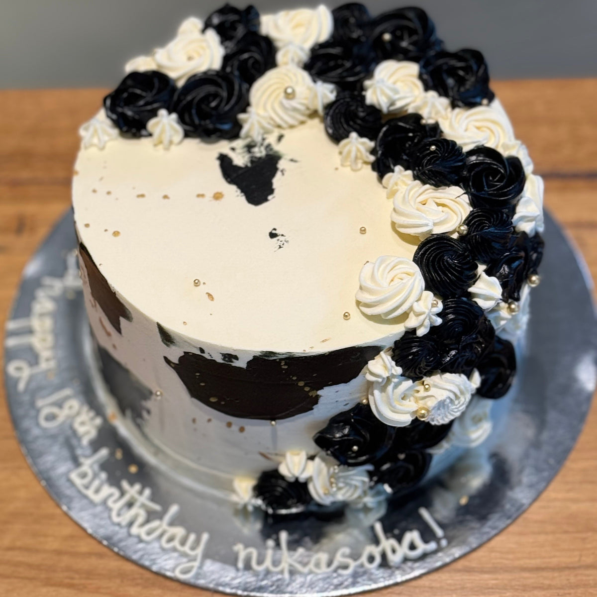 top view of a black, white and gold celebration cake in Adelaide, showcasing its dramatic colour contrast and cascading design.