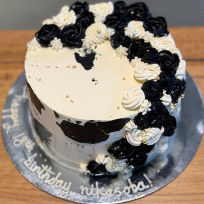 top view of a black, white and gold celebration cake in Adelaide, showcasing its dramatic colour contrast and cascading design.