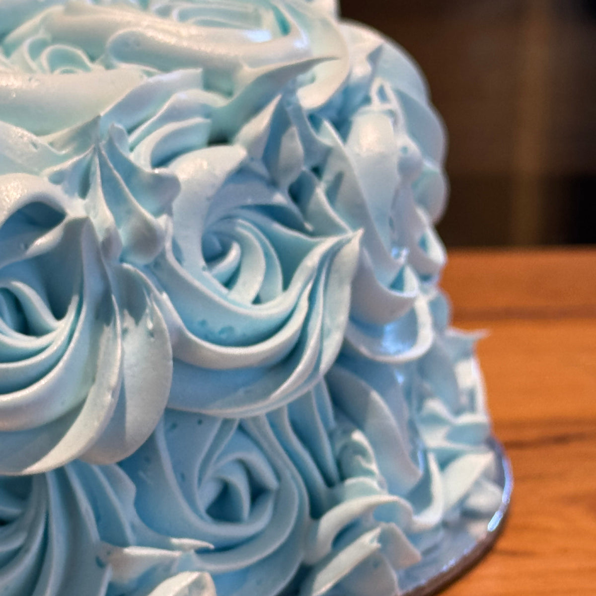 close up of a blue rosette cake made with Ben & Jerry's ice cream in Adelaide, showcasing its rose-shaped decorations.