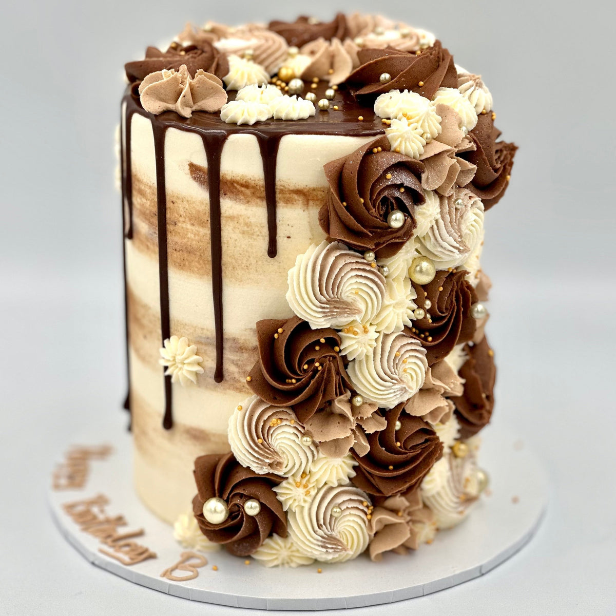 Full view of an elegant brown cascading mud or sponge cake handcrafted in Adelaide, featuring flowing decorative details and warm earthy tones.