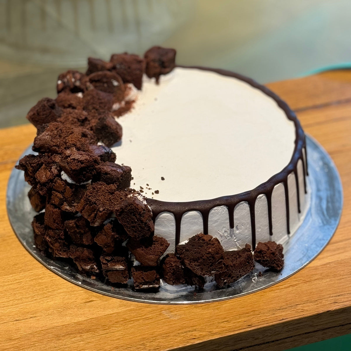 Full view of a brownie-loaded birthday cake handcrafted in Adelaide using Ben & Jerry's ice cream, generously decorated with brownie pieces.