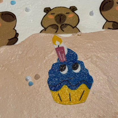 Close-up of cute capybara-themed decorations on a birthday cake handcrafted in Adelaide using Ben & Jerry's ice cream.