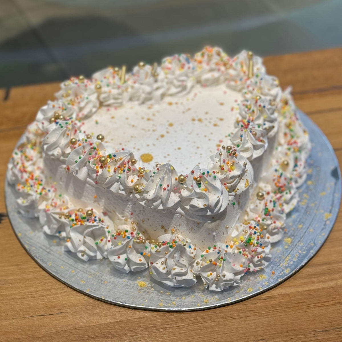 top view of an elegant heart birthday cake made with Ben & Jerry's ice cream in Adelaide, showcasing its sparkling gold dust decoration.