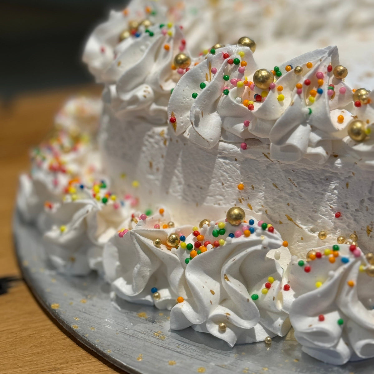 Close-up of shimmering gold dust accents on a heart-shaped celebration cake handcrafted in Adelaide using Ben & Jerry's ice cream.