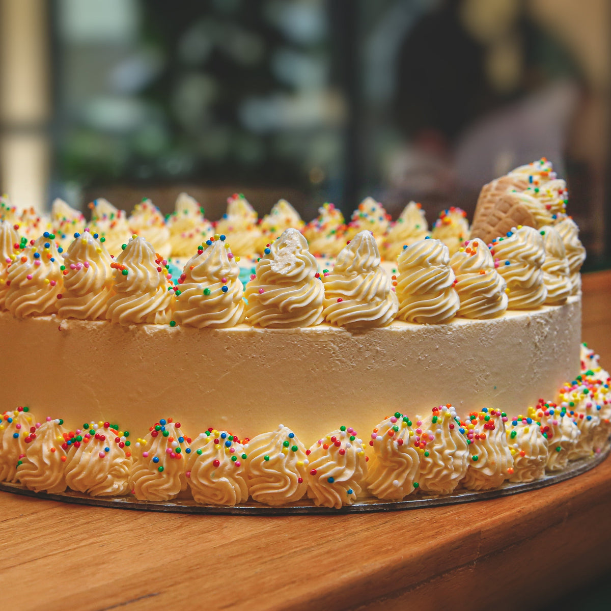 Front view of a Celebrations birthday ice cream cake showcasing its festive celebration-themed design.