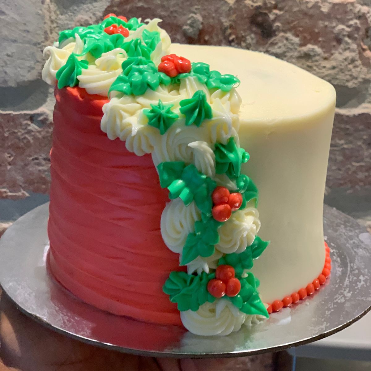 Front view of a tall mistletoe-themed Christmas cake made with Ben & Jerry's ice cream in Adelaide, showcasing its festive decorative styling.