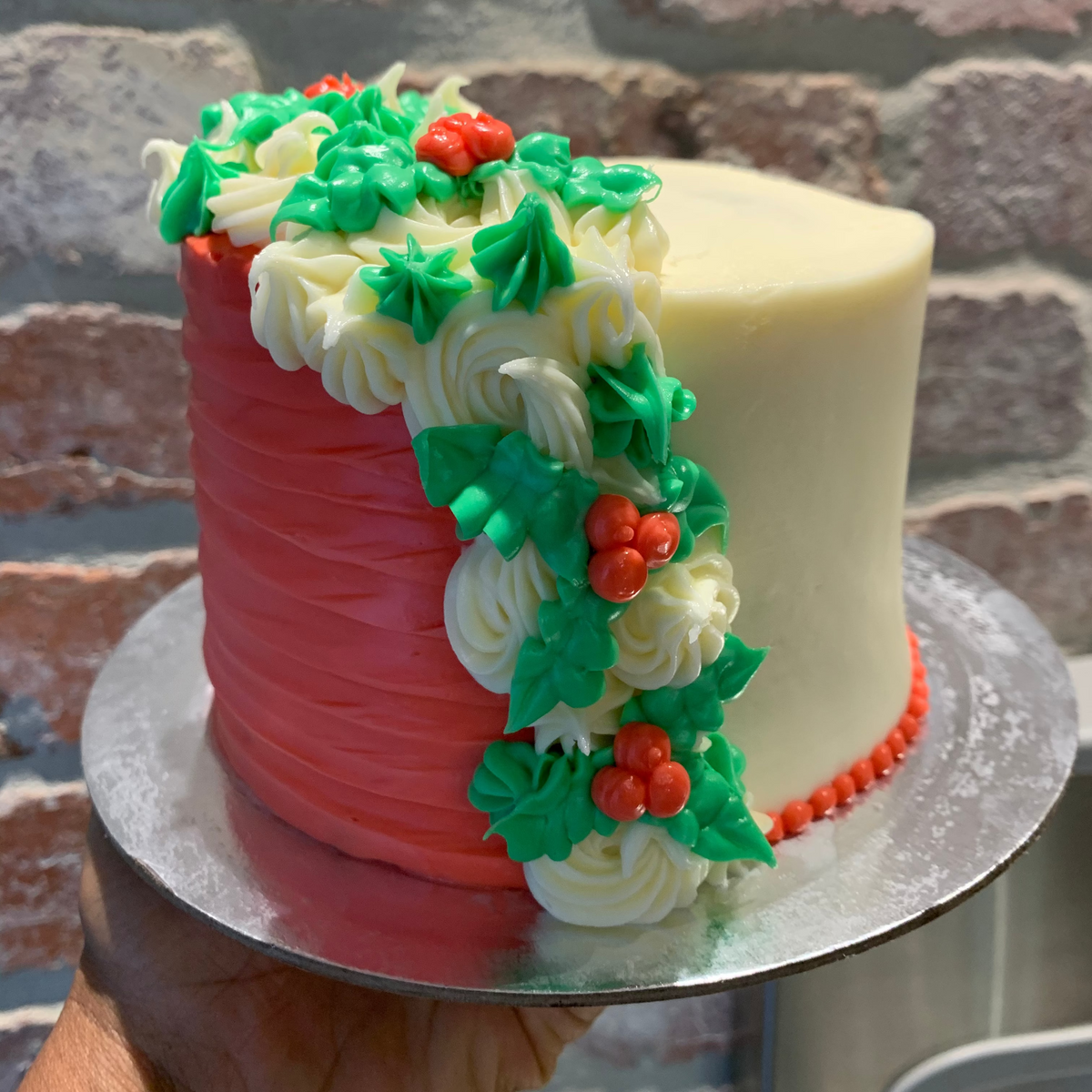 front view of a handcrafted tall Christmas ice cream cake made using Ben & Jerry's ice cream in Adelaide, highlighting its height and mistletoe-inspired design.