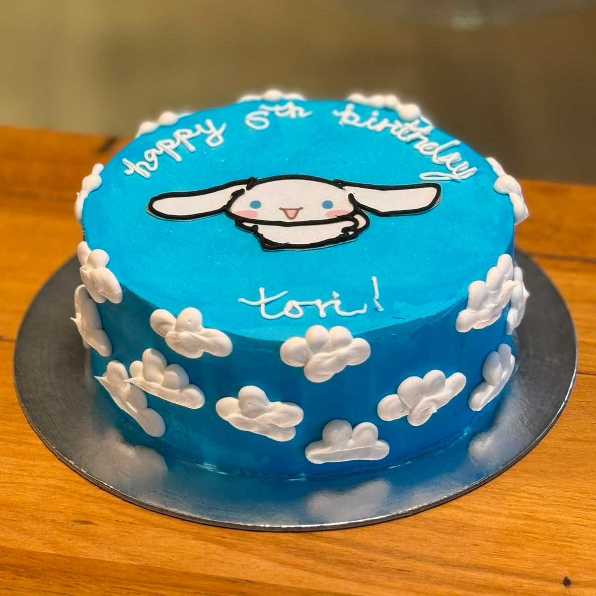 Full view of a Sanrio Cinnamoroll birthday ice cream cake featuring the adorable white puppy character in a kawaii-inspired design.