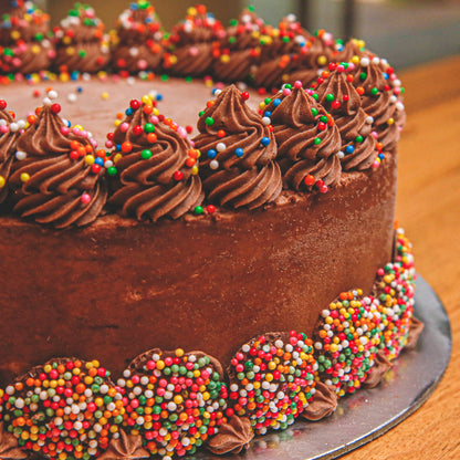 close up of a Classic Chocolate Celebrations birthday cake highlighting its chocolate-inspired design and decorative presentation.
