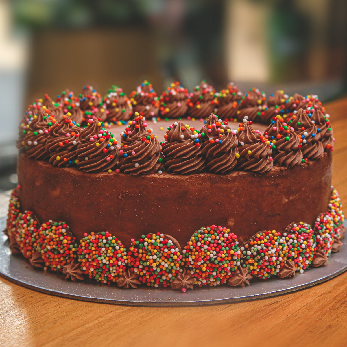 Front view of a handcrafted chocolate celebration cake showcasing its classic chocolate-themed decorative finish.