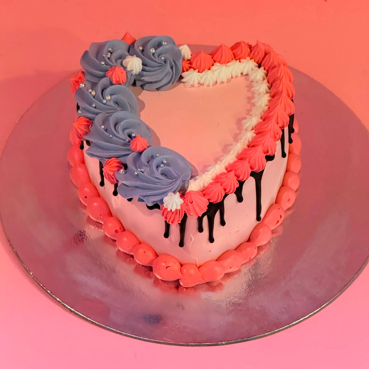 top view of a classic pink chocolate drip heart cake handcrafted in Adelaide using Ben & Jerry's ice cream, featuring a romantic heart-shaped design.