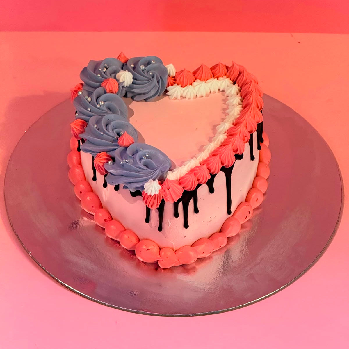 top view of a handcrafted pink heart ice cream cake in Adelaide made using Ben & Jerry's ice cream, highlighting its chocolate drip finish.