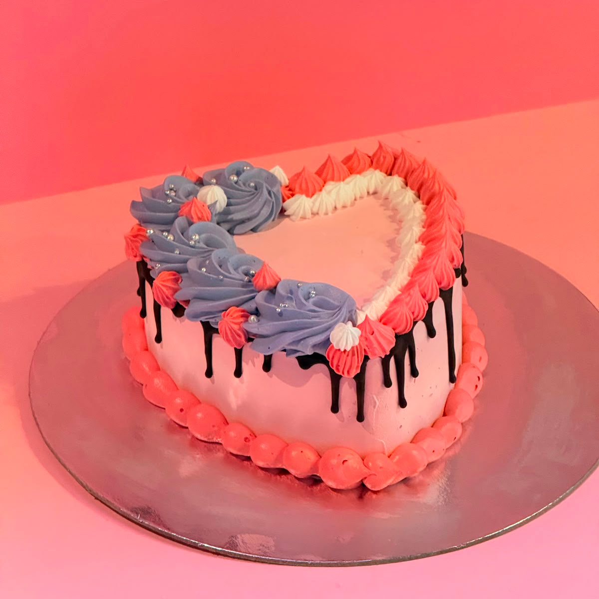 side view of the chocolate drip detailing on a pink heart-shaped birthday cake handcrafted in Adelaide using Ben & Jerry's ice cream.