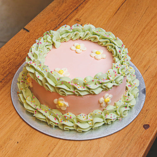 Full view of a handcrafted daisy flower birthday ice cream cake featuring cheerful floral decorations for a garden-inspired celebration.