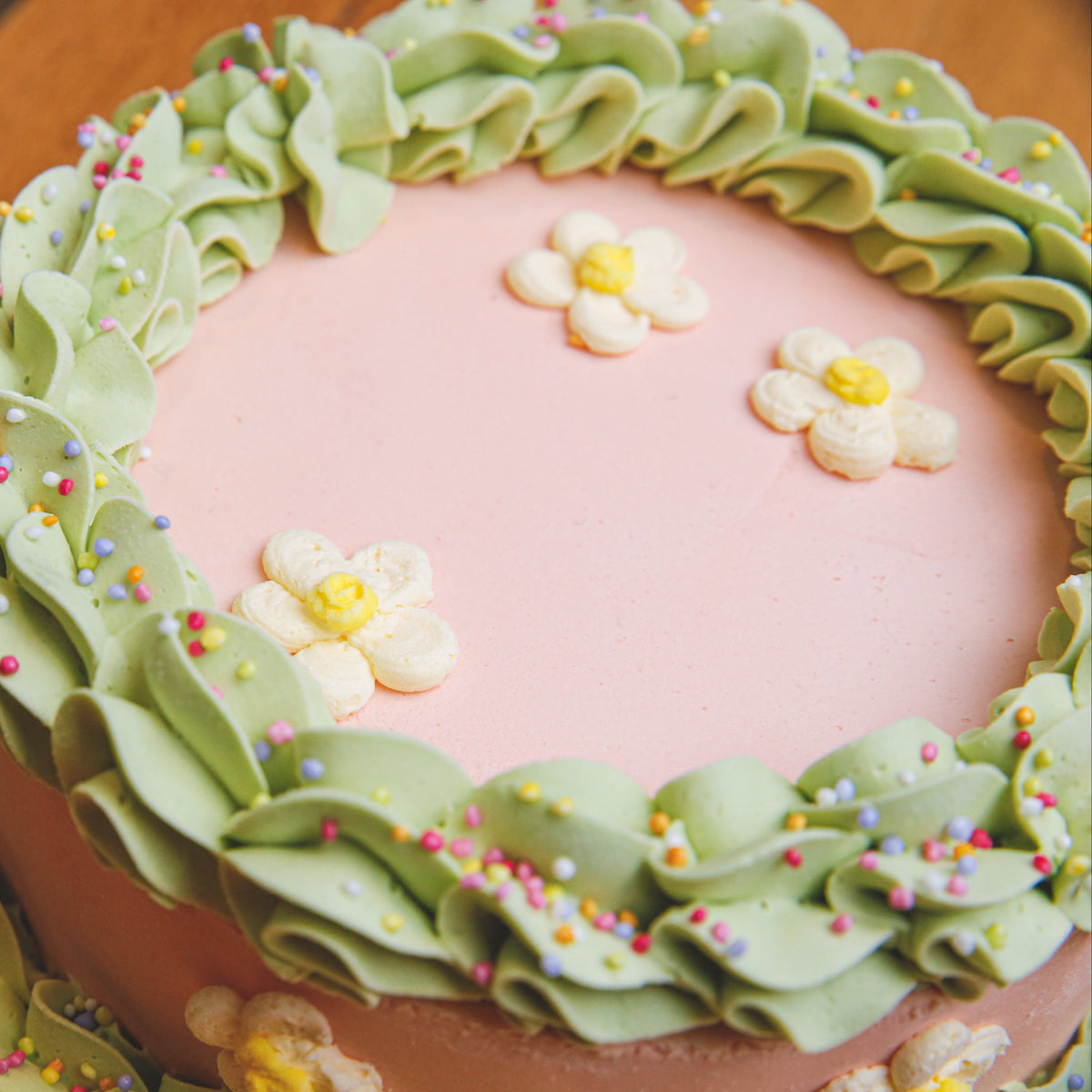 Close-up view of daisy-inspired floral decorations on a handcrafted birthday ice cream cake.