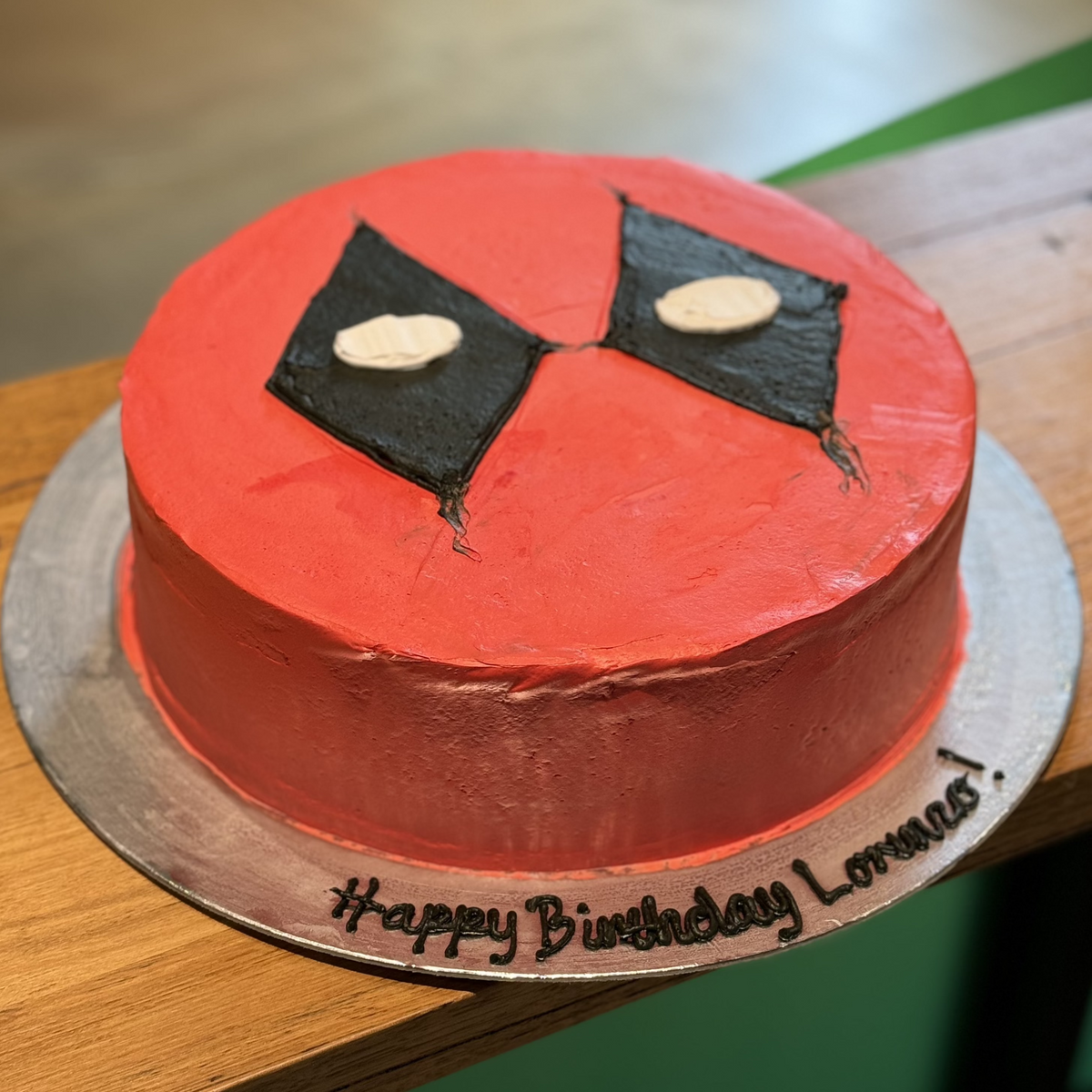 Full view of a Deadpool-themed birthday cake handcrafted in Adelaide using Ben & Jerry's ice cream, featuring bold red-and-black superhero styling.