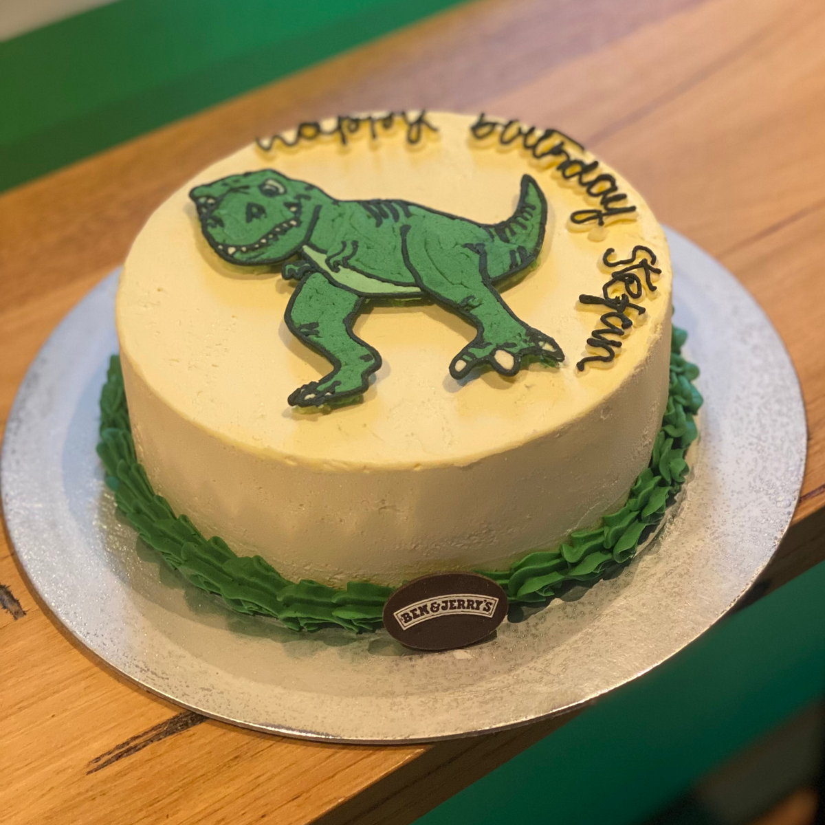front view of a handcrafted dinosaur ice cream cake made using Ben & Jerry's ice cream in Adelaide, highlighting its prehistoric birthday theme.