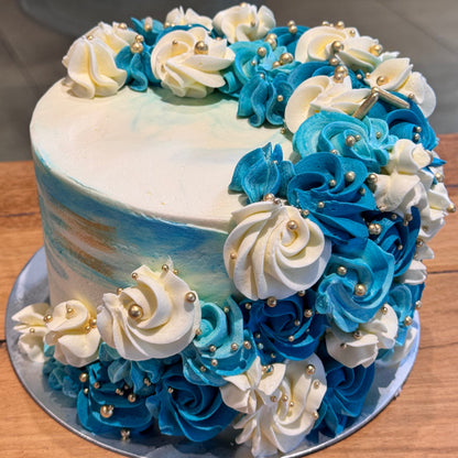 Full view of an elegant blue, white and gold mud or sponge cake handcrafted in Adelaide, featuring graceful cascading decorations.