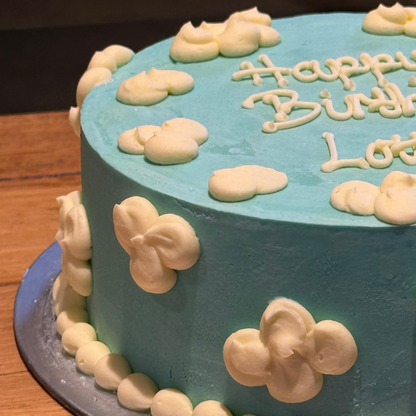 close up of a cloud-themed birthday ice cream cake showcasing soft, fluffy cloud-inspired decorations and a whimsical finish.