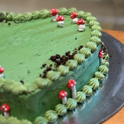 Close-up of mushroom decorations and Oreo-inspired accents on a heart-shaped cake handcrafted in Adelaide using Ben & Jerry's ice cream.