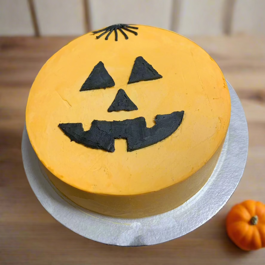 top  view of a scary pumpkin Halloween cake handcrafted in Adelaide using Ben & Jerry's ice cream, featuring a spooky jack-o'-lantern-inspired face.