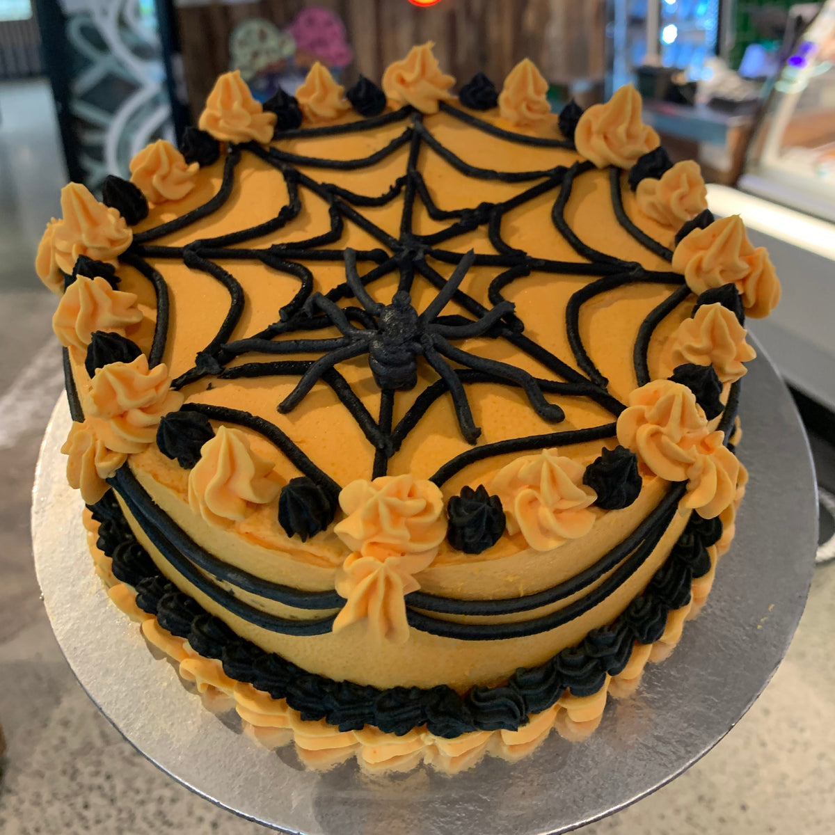 top view of the spider-inspired decorations and cobweb detailing on a Halloween cake handcrafted in Adelaide using Ben & Jerry's ice cream.