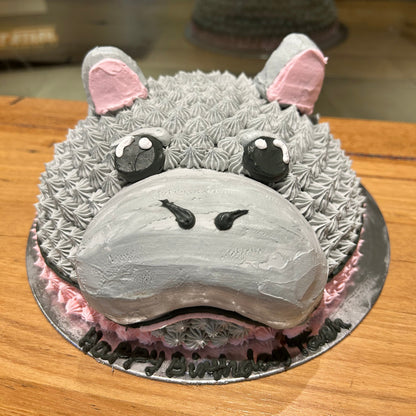 front view of the cute hippopotamus-inspired facial decorations on a dome cake handcrafted in Adelaide using Ben & Jerry's ice cream.