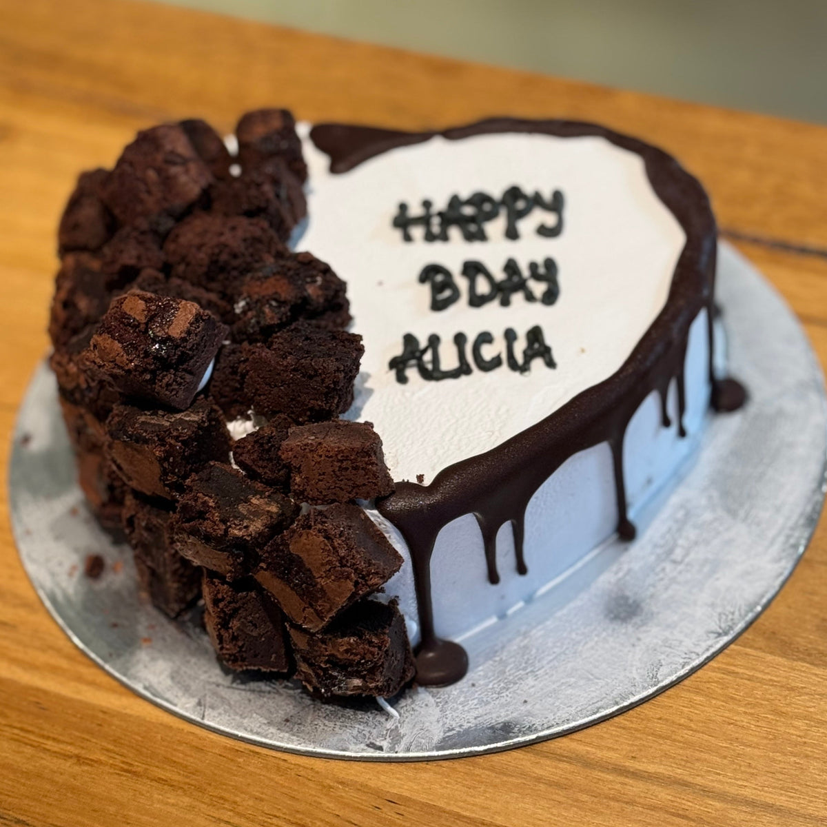 Full view of a loaded brownie heart cake handcrafted in Adelaide using Ben & Jerry's ice cream, featuring chocolatey toppings.