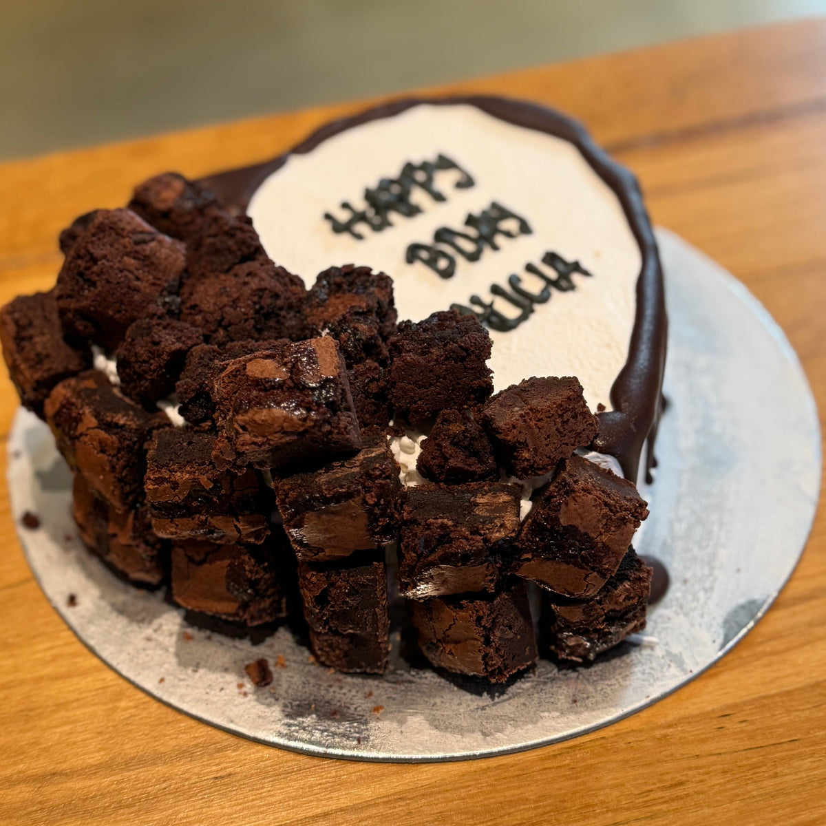 Side view of a loaded brownie heart cake handcrafted in Adelaide using Ben & Jerry's ice cream, highlighting its decorative toppings.