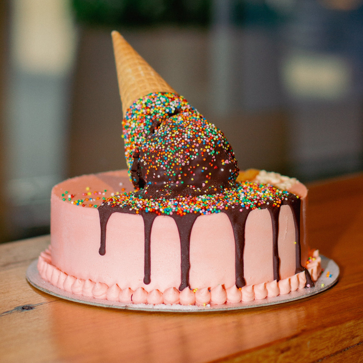 Full view of a melting ice cream cone birthday cake featuring a playful cone topper and melting scoop-inspired design for celebrations.