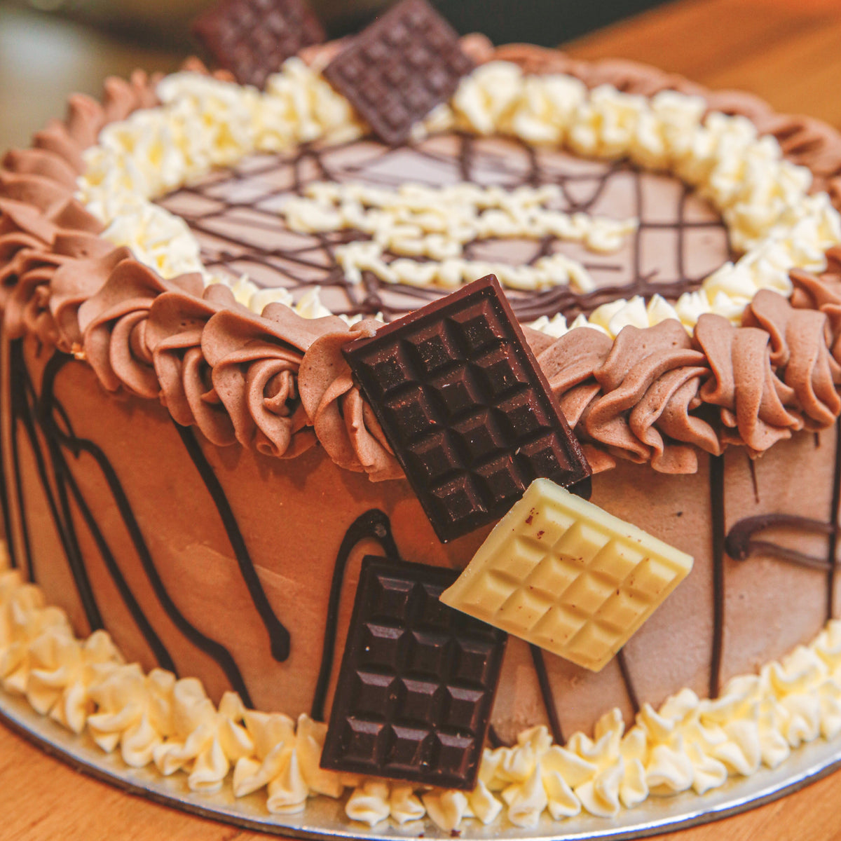 close up of a chocolate bar birthday cake highlighting its decorative chocolate treats and chocolate-inspired finish.