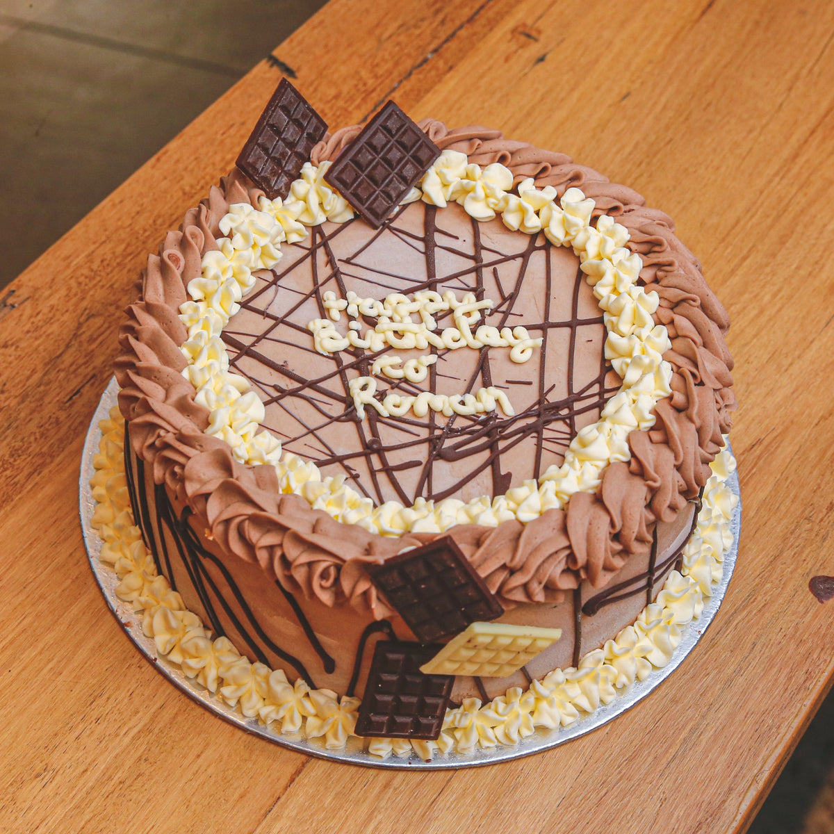 front view of Mini Chocolate Bars Loaded Ice Cream Cake stacked with assorted bite-size chocolates for birthday celebrations with Adelaide delivery